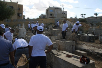  بالفيديو: أبناء "الجديدة المكر" يباشرون بترميم القبور في مقبرة الكازاخانة ضمن معسكر التواصل